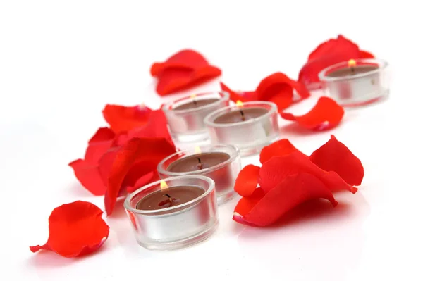 玫瑰花瓣和燃烧的蜡烛 — 图库照片