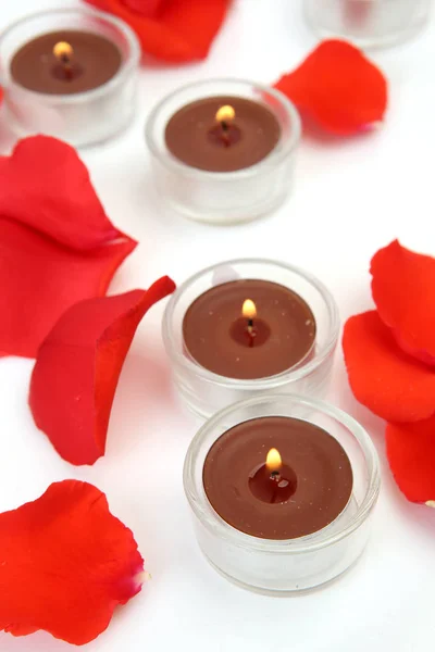 Pétalas de rosa e velas acesas — Fotografia de Stock