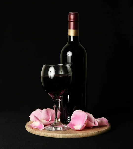 Uma garrafa de vinho sobre um fundo preto — Fotografia de Stock