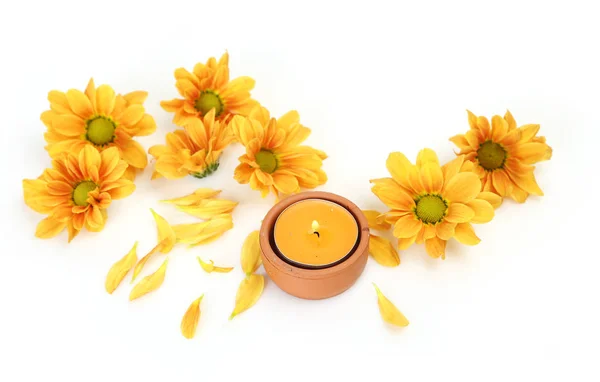 Yellow candle in a clay candlestick and yellow flowers on a whit — Stock Photo, Image