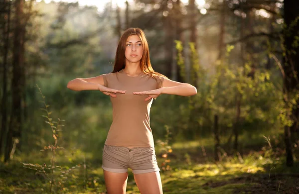Meisje het uitvoeren van gymnastiek oefeningen in het bos — Stockfoto