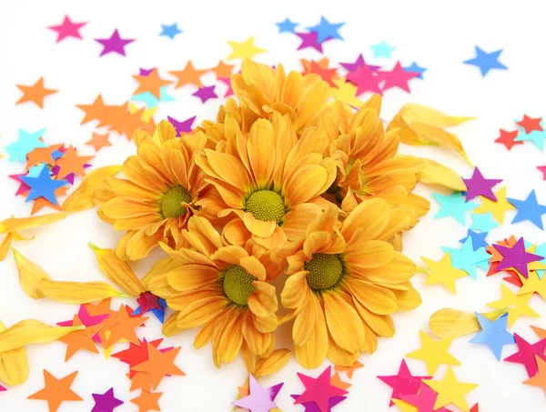 黄色の菊と多色の星型のコンフェッティ — ストック写真