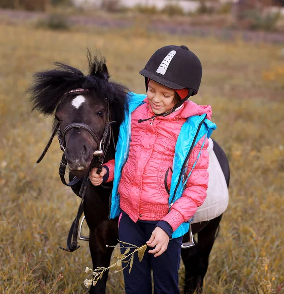 Flicka Hjälm Promenader Med Svart Ponny Stockbild