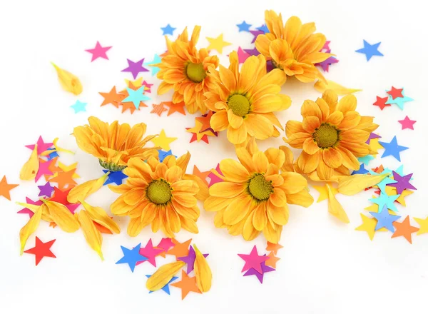 黄色の菊と多色の星型のコンフェッティ ストック画像