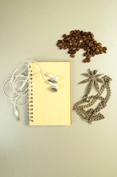 Graines de café, collier, carnet de notes et écouteurs — Photo