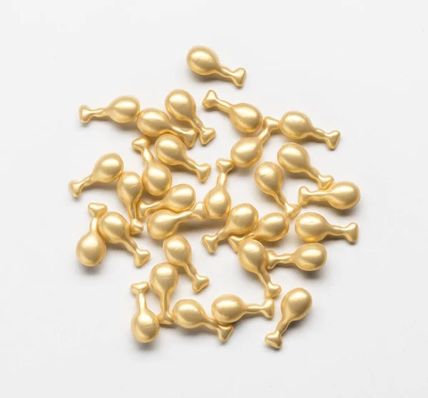 Golden capsule with a cream for face — Stock Photo, Image