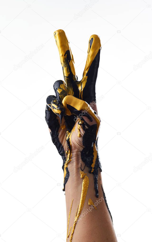 Female hand in liquid black and golden oil