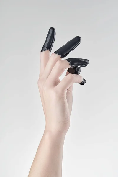 Kvinnlig hand i svart olja — Stockfoto