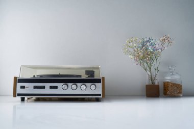 Retro stereo radyosu ve açık gri arka planda bir buket çiçekli diğer antika eşyalar.