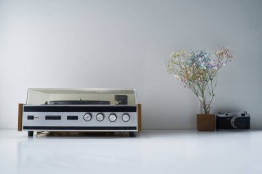 Retro stereo radyosu ve açık gri arka planda bir buket çiçekli diğer antika eşyalar.