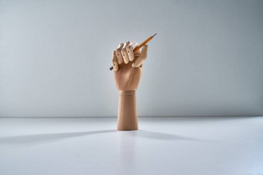 Gri bir arka planı olan tahta bir el.