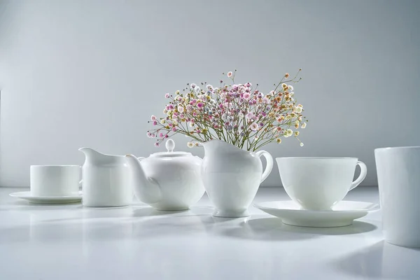 配以淡灰色背景的白瓷茶具 配以精致的花束 — 图库照片