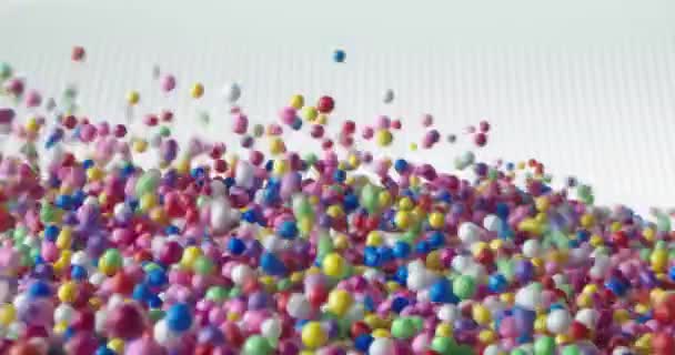 多色球下落并向不同方向散射 在白色表面滚动 — 图库视频影像