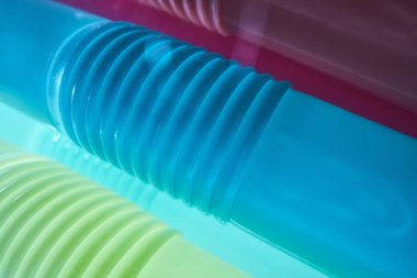 Koyu arkaplandaki çok renkli plastik kokteyl tüplerinin arka planı