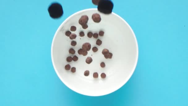 Schokolade Und Köstliche Frühstückszerealien Fallen Eine Weiße Tasse Vor Leuchtend — Stockvideo