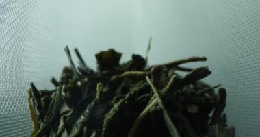 İçinde kaba yaprak siyah çay olan bir çay poşetinin içinde.