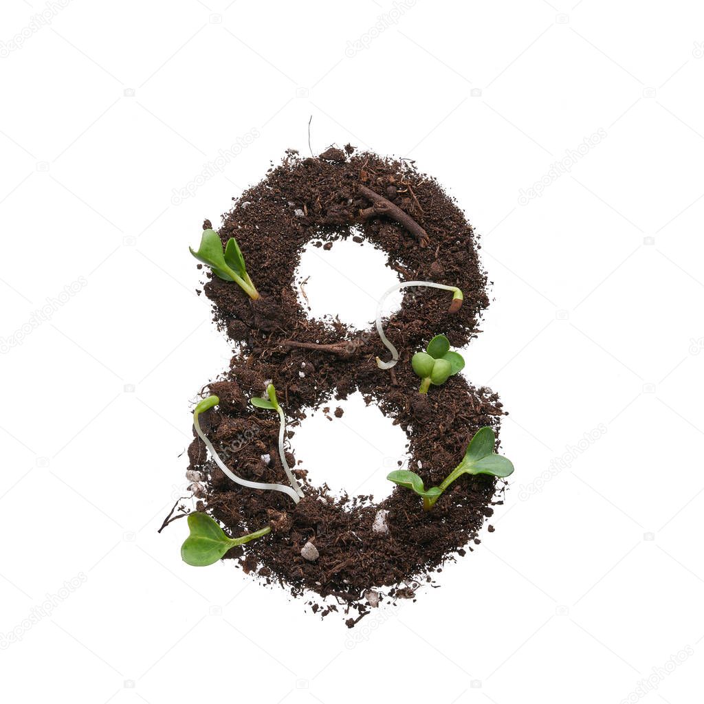 Figures isolated on a white background. A stencil in the shape of a figure is created using earth with young sprouts.