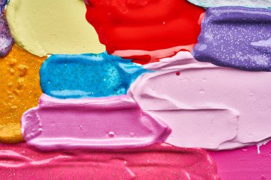 Beyaz arka planda parıltıları olan çok renkli akrilik boya dokusu ve vuruşları