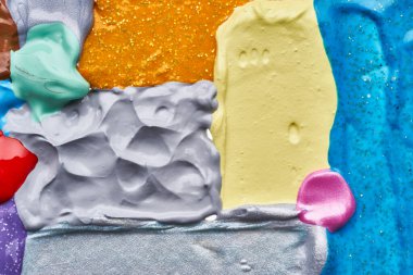 Beyaz arka planda parıltıları olan çok renkli akrilik boya dokusu ve vuruşları