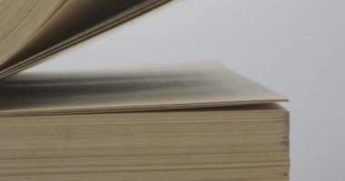 Sarı sayfaları ve siyah kapağı olan eski bir kitabın sayfalarını çeviriyorum.