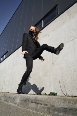 Siyah koruyucu maskeli ve siyah güneş gözlüklü genç kız, virüse karşı korunuyor.