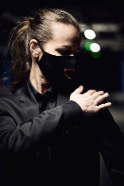 Siyah koruyucu maskeli ve siyah güneş gözlüklü genç kız, virüse karşı korunuyor.