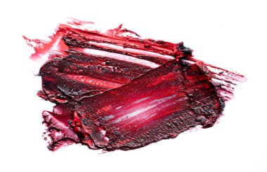 İki renkli ruj, kırmızı ve siyah, kırık ve ezilmiş beyaz arka planda..