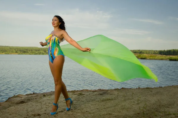 Prachtige volwassen vrouw in bikini en met pareo op het strand door t — Stockfoto