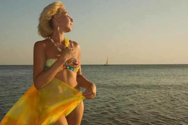 Mooie vrouw in bikini en met pareo op het strand — Stockfoto