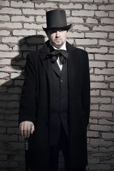 Homme victorien en manteau noir, haut de forme et cravate — Photo