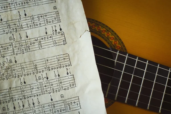 Detail der Akustikgitarre mit altem Partiturfragment — Stockfoto