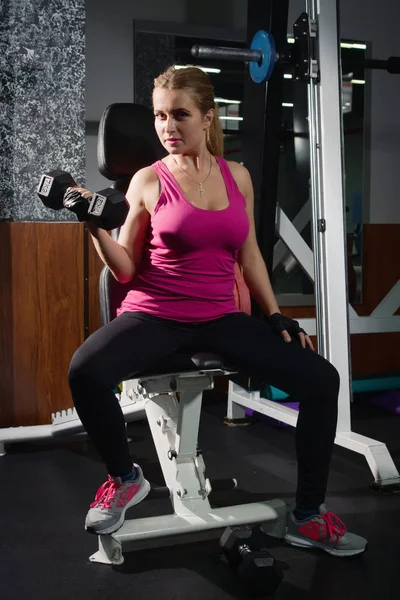 Chica fiit haciendo ejercicios con pesas en el gimnasio —  Fotos de Stock