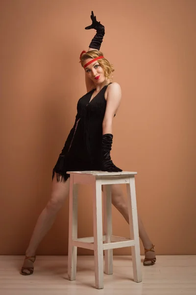 Vackra skådespelerskan i svart retro klänning med pannband — Stockfoto