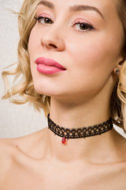 Beautiful woman showing her neck with a choker on it clipart