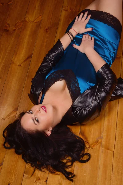 Jeune femme habillée en robe courte en dentelle repose sur un plancher — Photo