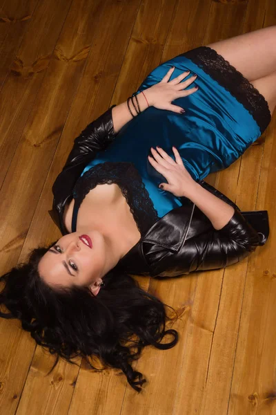 Young woman dressed in short lace dress lies on a floor — Stock Photo, Image