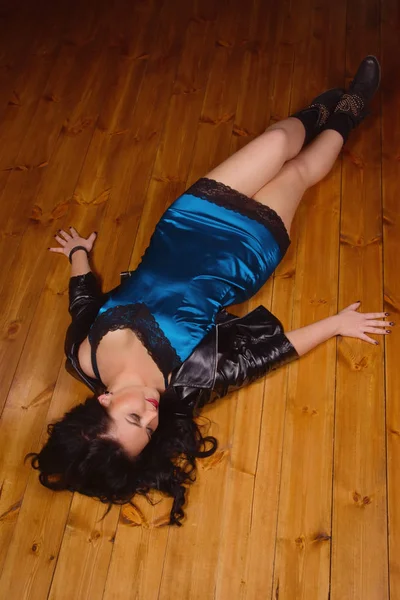 Jovem mulher vestida com vestido de renda curta jaz em um chão — Fotografia de Stock