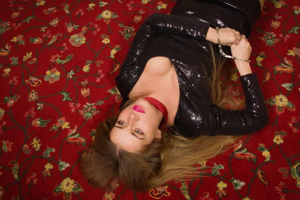 검은 드레스에 목 졸려 아름 다운 여자는 바닥에 놓여 있습니다. 시 — 스톡 사진