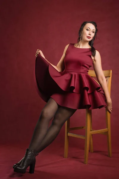 Hermosa mujer vestida con vestido rojo en un interior vintage — Foto de Stock