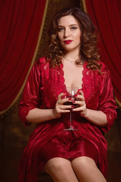 Kablosuz bir bardak kırmızı iç çamaşırı giyen güzel esmer kadın — Stok fotoğraf