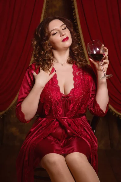 Kablosuz bir bardak kırmızı iç çamaşırı giyen güzel esmer kadın — Stok fotoğraf