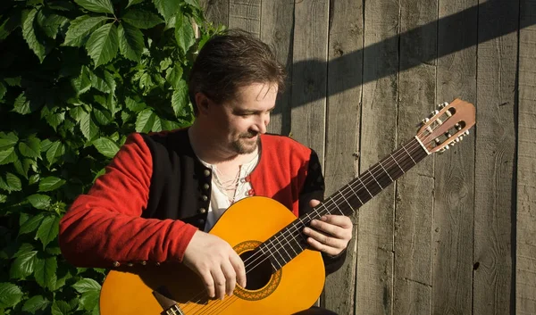 Erwachsener Mann spielt Gitarre im Sommergarten — Stockfoto