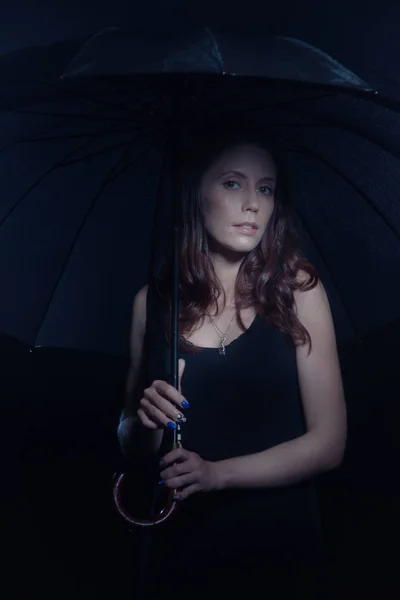 Young girl under an umbrella in the rain — Stock Photo, Image