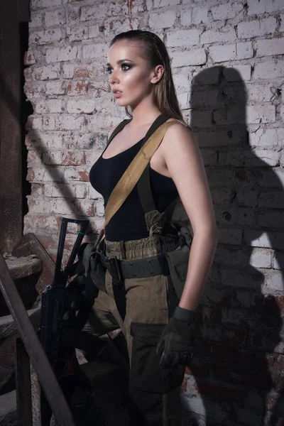 Fille avec une arme dans une usine abandonnée — Photo