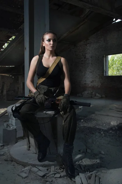 Girl with a gun in an abandoned factory — Stock Photo, Image