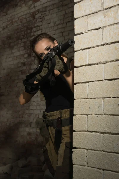 Uma rapariga com uma submetralhadora dispara — Fotografia de Stock