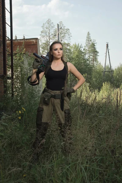 Девушка с пистолетом на заброшенной фабрике — стоковое фото