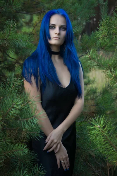 Όμορφη γυναίκα με σκούρα μπλε μαλλιά, ντυμένη με μαύρο φόρεμα στην ου — Φωτογραφία Αρχείου