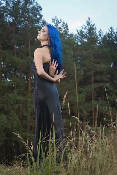 Hermosa mujer con cabello azul oscuro vestida con vestido negro en th —  Fotos de Stock