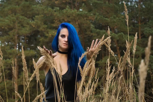 Hermosa mujer con cabello azul oscuro vestida con vestido negro en th —  Fotos de Stock
